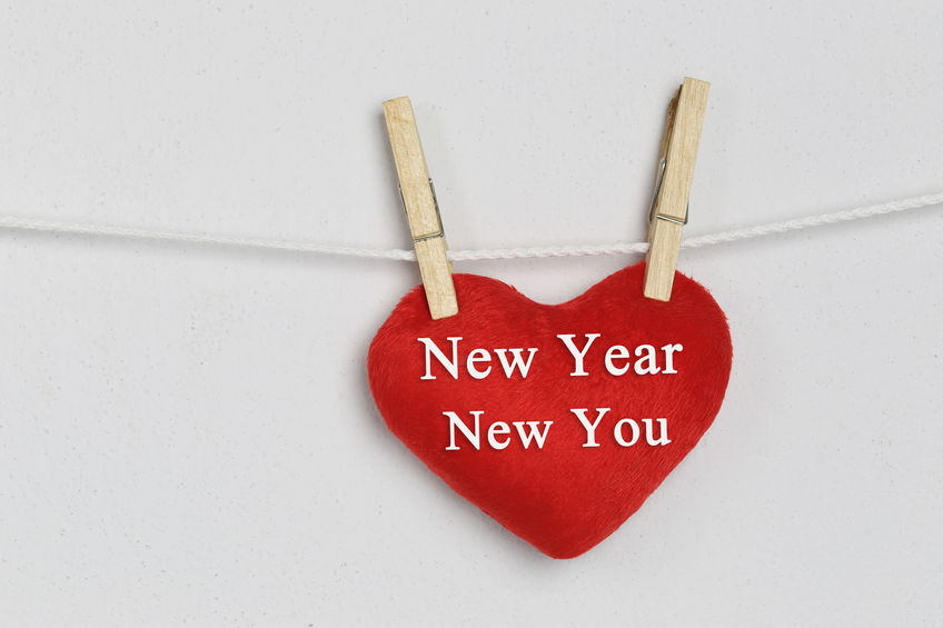 Red heart hanging on a rope and have New year New you text.