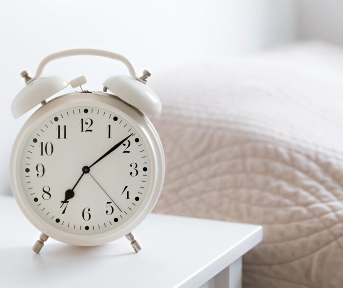 Large white alarm clock on bedside table